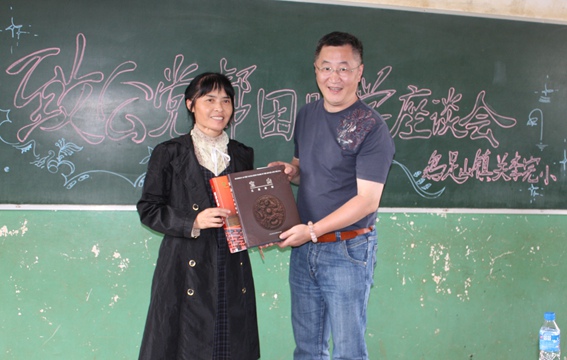 舒东清（左）在2012年关李完小同心助学活动座谈会上代表州委会接受上海宝山区总支部赠送的纪念品